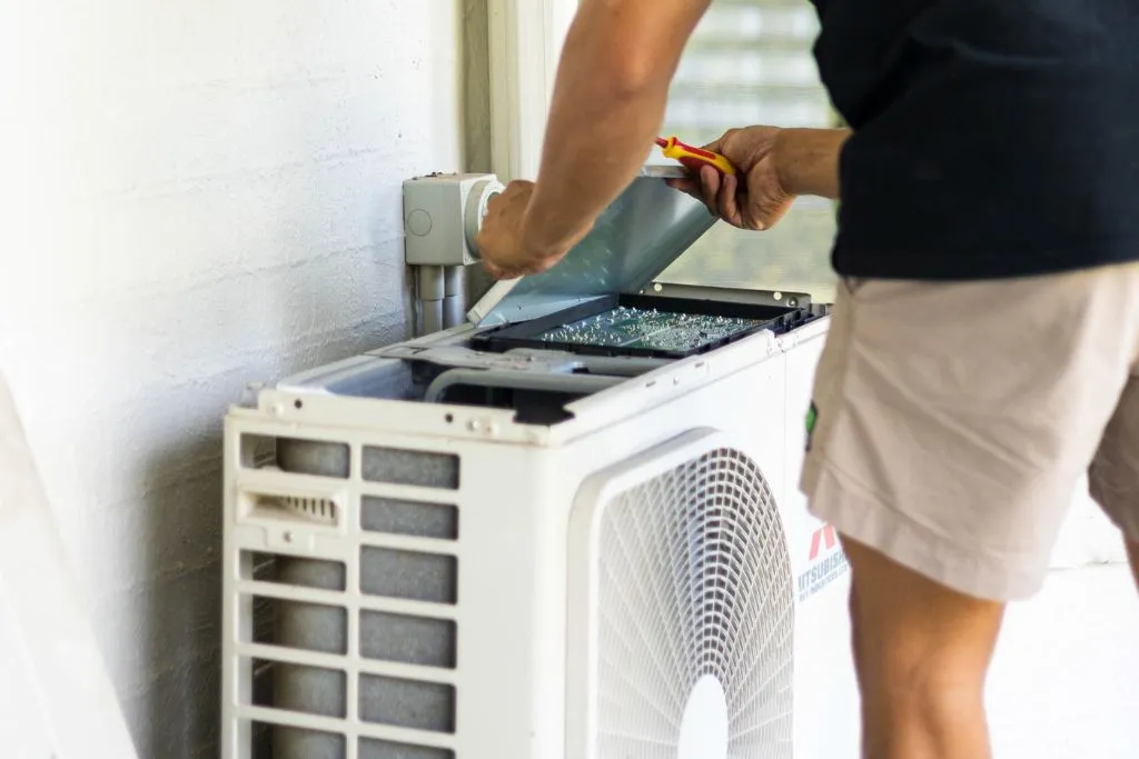JVK technician installing split system air conditioner on Gold Coast property